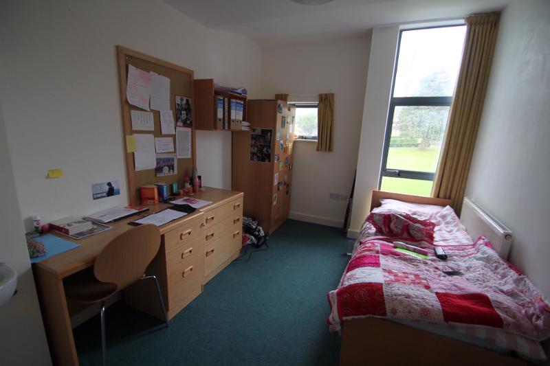 Habitación individual con ventana, armario y escritorio en el curso de ingles en inglaterra