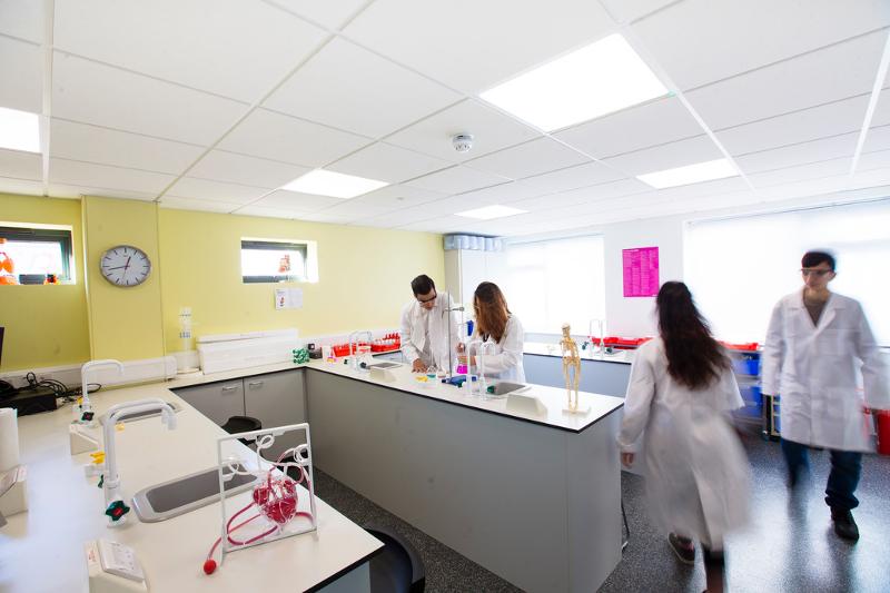 Jóvenes con sus batas en un laboratorio en el curso verano inglaterra