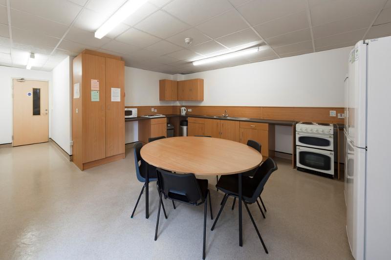 Sala común con mesa y sillas y cocina en el curso ingles extranjero