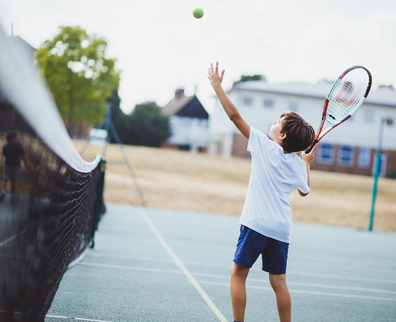 Niño jugando al tenis en el curso de ingles en inglaterra 