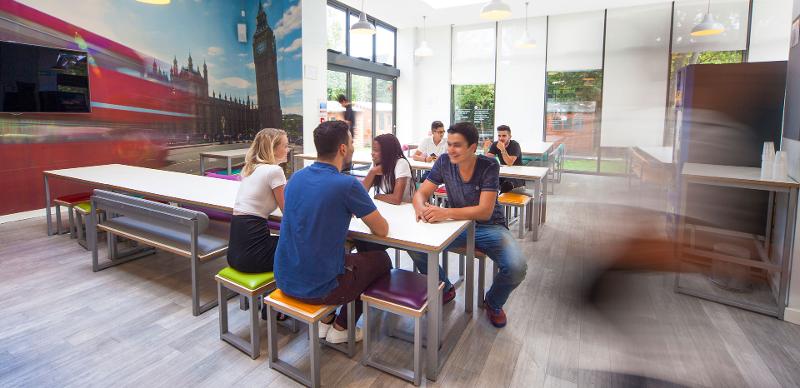 Grupo de jóvenes sentados en el comedor del curso de inglés en inglaterra 