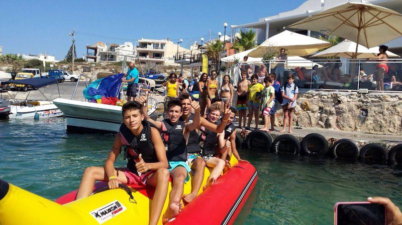 Jóvenes en el curso de idiomas en malta montado en una banana hinchable