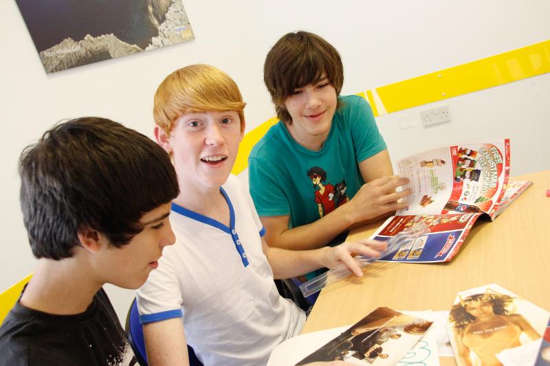 Jóvenes leyendo unas revistas en el curso de idiomas en malta