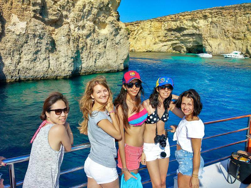 Chicas posando encima de un barco con el mar de fondo en el curso de idiomas en malta