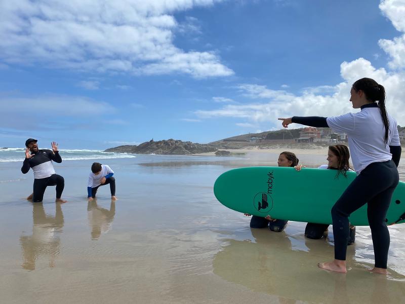 Gente haciendo surf en el campamento de vacaciones