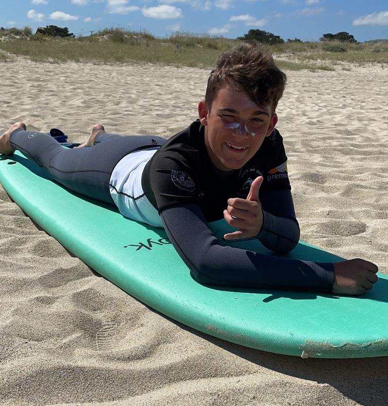 Joven participante divirtiéndose y aprendiendo surf en la arena del surfcamp gran canaria