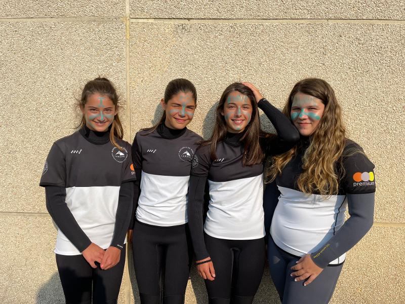Cuatro participantes con pintura de surferos posando para una foto en el surf camp gran canaria