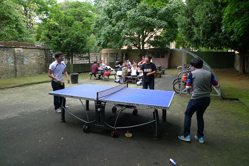 Grupo de participantes jugando al ping-pong en el descanso del curso de idiomas en inglaterra 