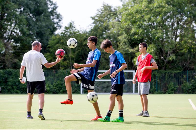 Participantes entrenando en la pista de fútbol en los cursos de ingles en cambridge