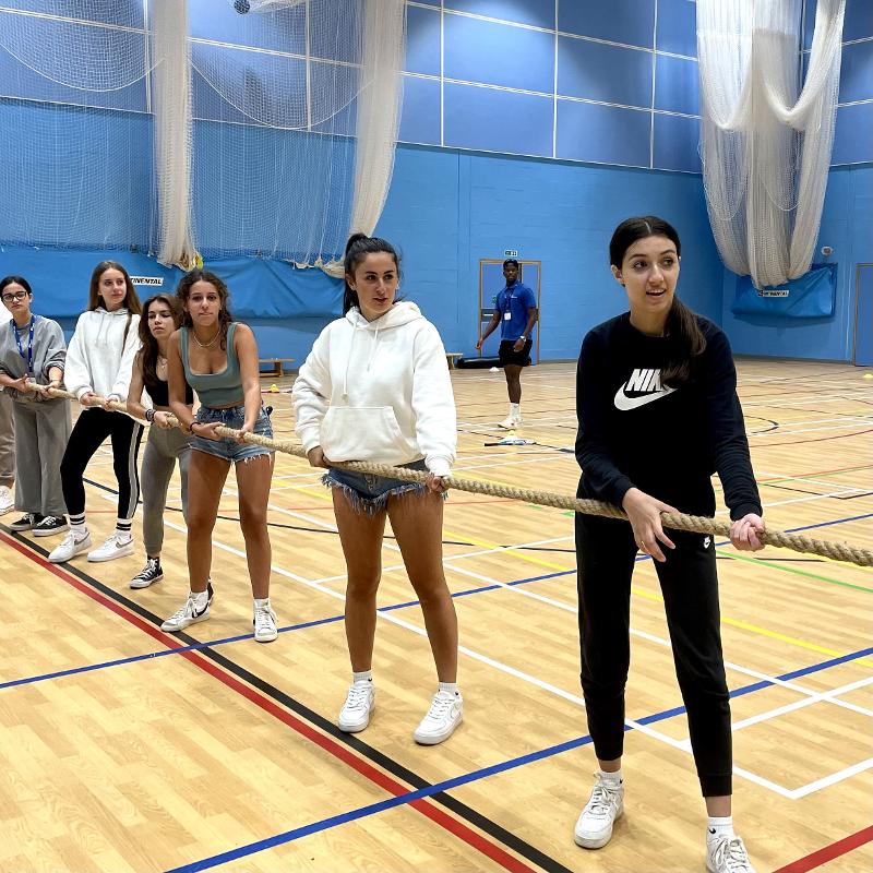 Chicas en la cancha de baloncesto jugando al tira y afloja en el curso de ingles inglaterra