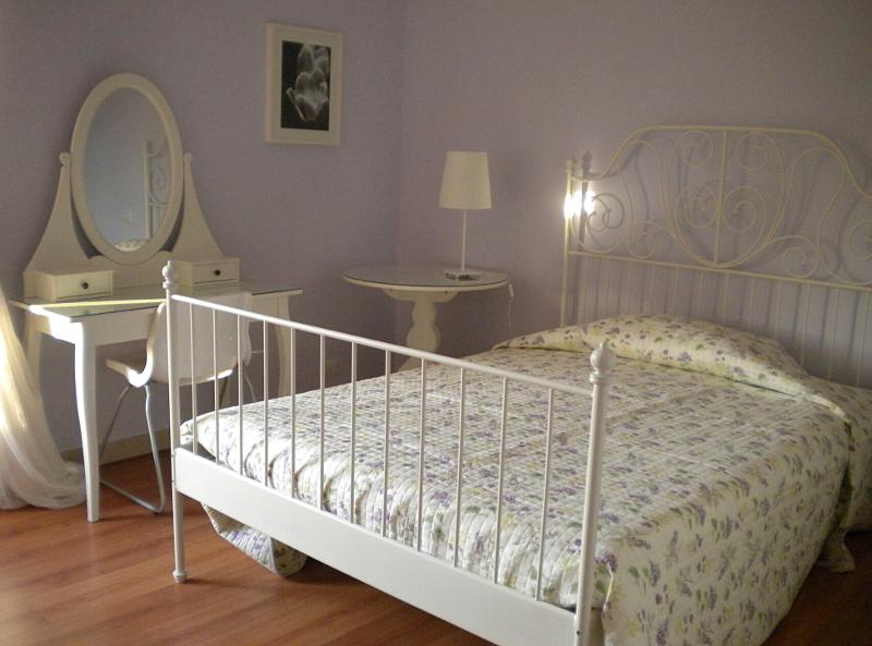 Dormitorio en casa de acogida con cama de matrimonio, totalmente equipado y decorado en color blanco en el curso de idiomas en italia