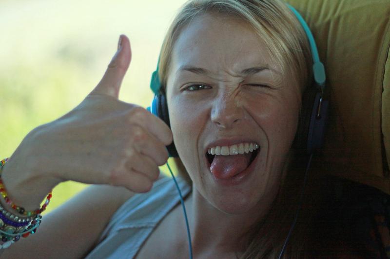 Jóven contenta, sonriendo y sacando la lengua en el autobús en el curso de idiomas en italia 