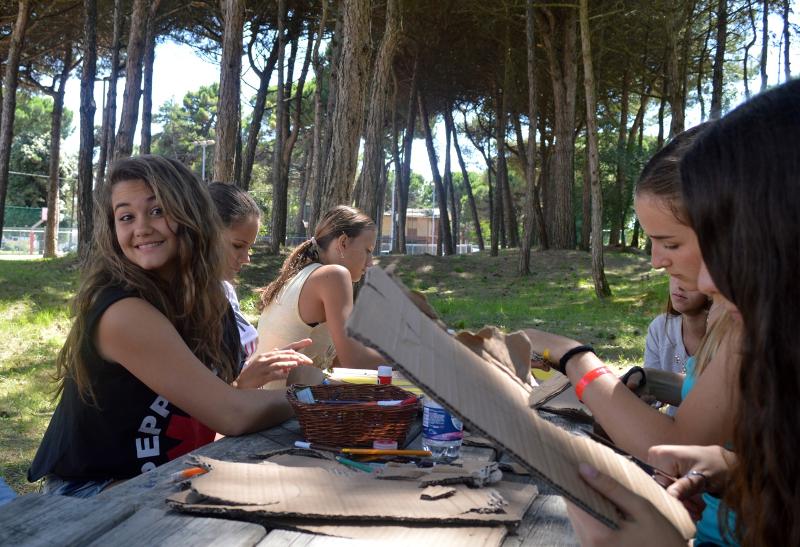 Chicas haciendo un taller de manualidades en la naturaleza en el curso de italiano en italia 
