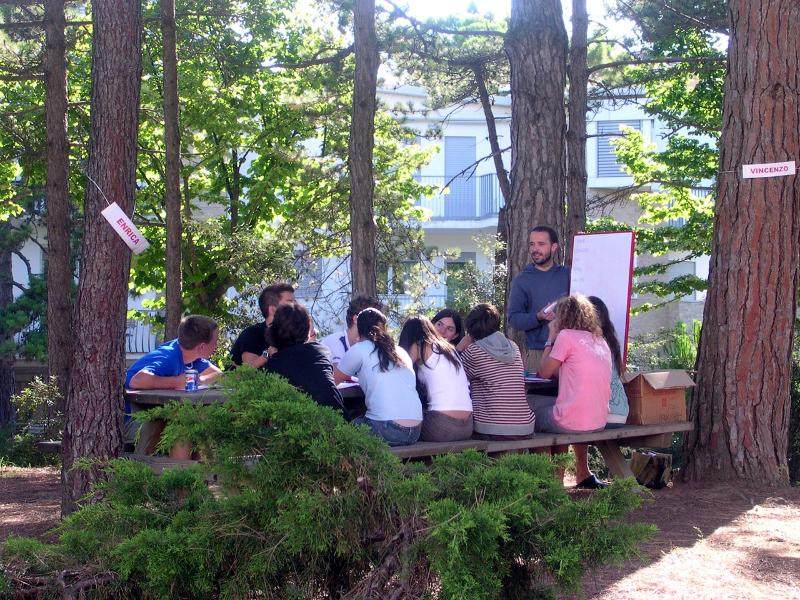 Grupo de jovenes dando clase de italiano al aire libre en el curso de idiomas en italia 