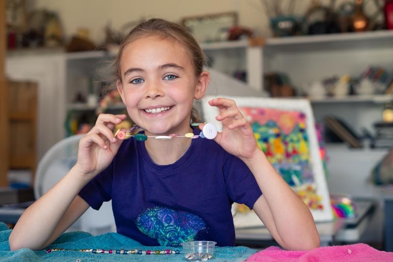 Niña haciendo collares con botones en los talleres de manualidades del curso ingles escocia 