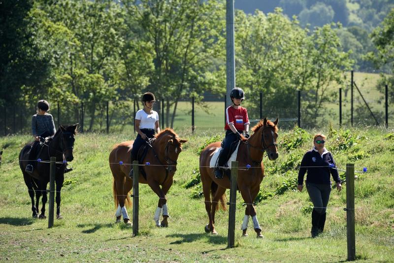 Tres jóvenes montando a caballo junto a la instructora en el curso ingles escocia 