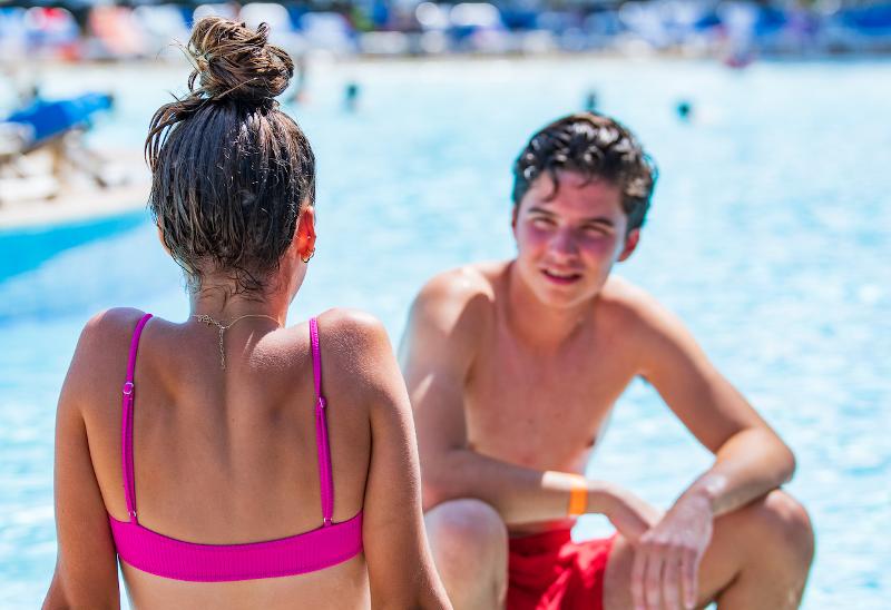 Un chico y una chica hablan en la piscina en el curso de idiomas en francia