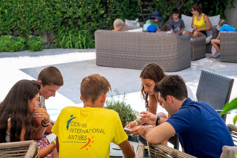 Grupo de estudiantes jugando a las cartas en el curso de idiomas en francia