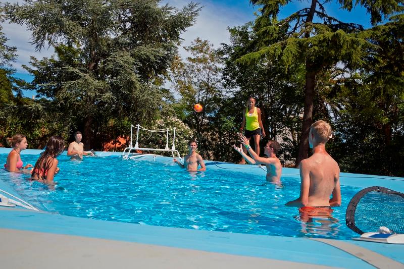 Niños jugando a la pelota en la piscina en un curso de francés Francia