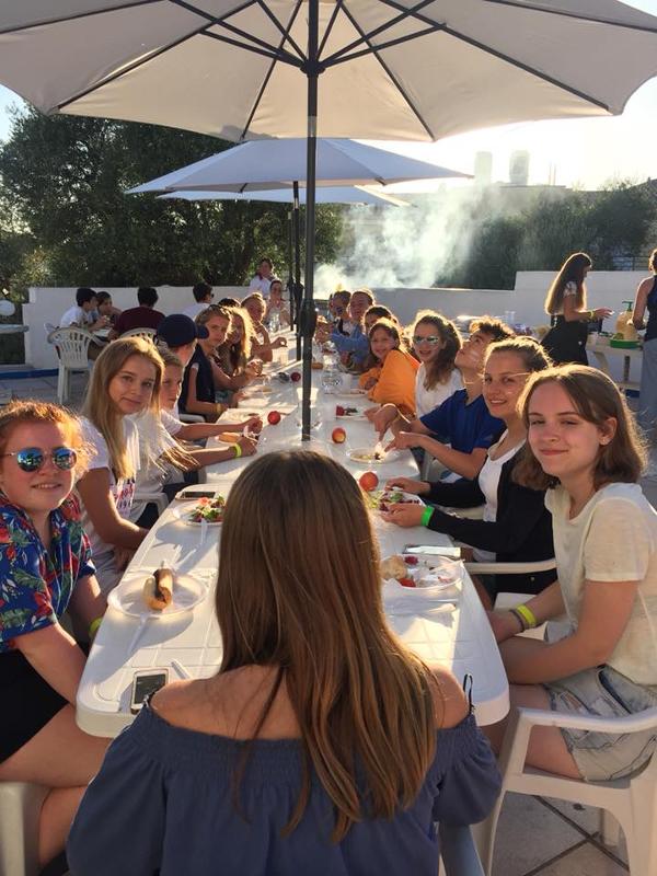 Participantes comiendo todos juntos perritos calientes en la terraza del curso de frances en francia