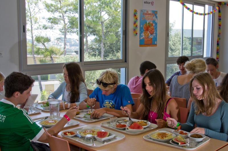 Jóvenes disfrutando de una agradable comida deliciosa en el buffet del curso de idiomas francia 