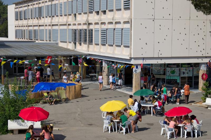 Terraza del curso de idiomas francia con sombrillas de colores y jóvenes disfrutando 