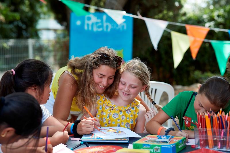 Monitora pintando con una participante en el taller de manualidades del curso de frances francia 