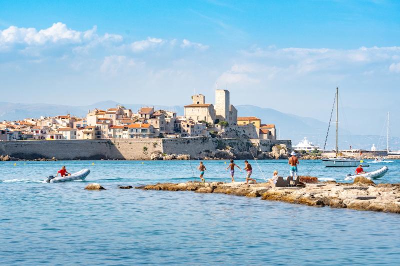 Foto del mar y niños jugando en las rocas en curso de idiomas en francia 