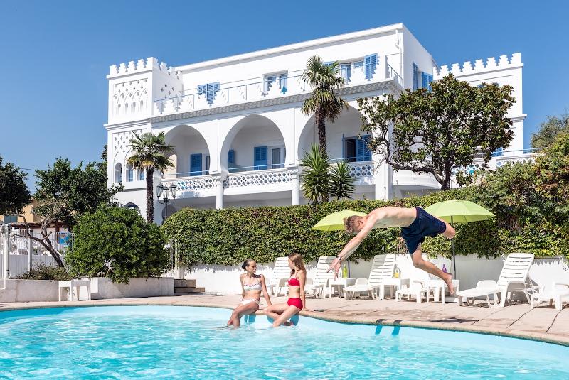 Jóven tirándose de cabeza y disfrutando de la piscina del curso de idiomas francia 