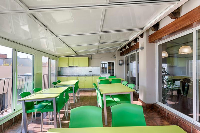 Terraza con cocina, mesas y sillas en el curso de español en españa