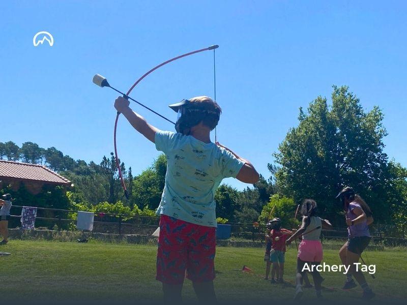 Niños haciendo tiro con arco en el campamento de verano