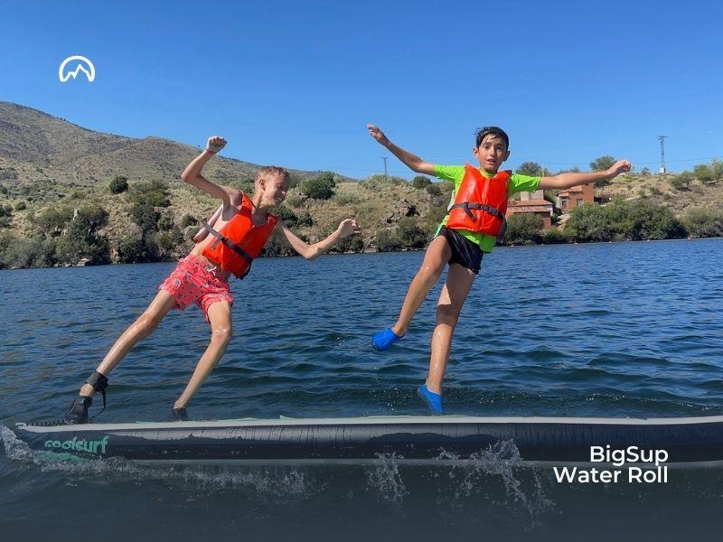 Niños haciendo BigSup en un lago en el campamento verano