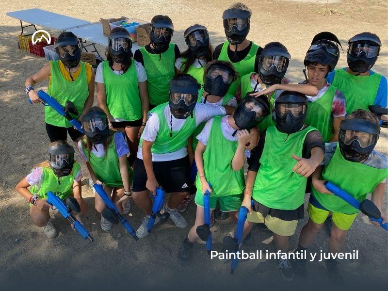 Grupo de participantes del campamento de verano posando con su equipación de paintball