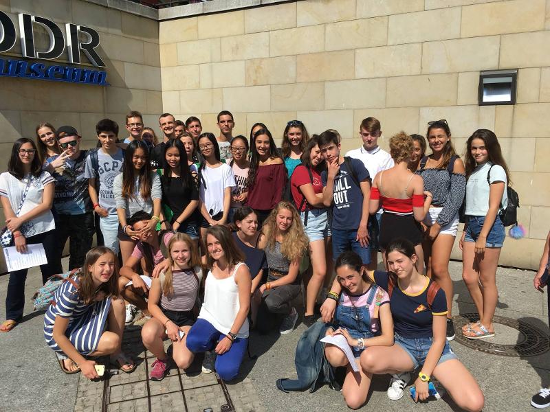 Jóvenes y niños de un campamento en una foto de grupo bajo el sol en un campamento de verano en alemania para jovenes