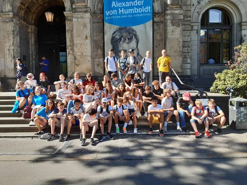 Jóvenes sentados posando en las escalerasde la universidad alemana de Humboldt en campamento alemania verano