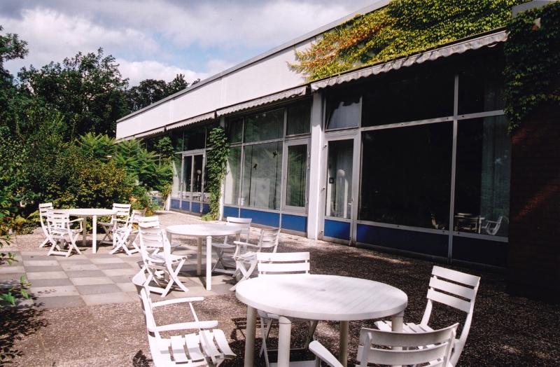Merendero con mesas y sillas frente a la cafeteria en la naturaleza en curso de idiomas juvigo en alemania