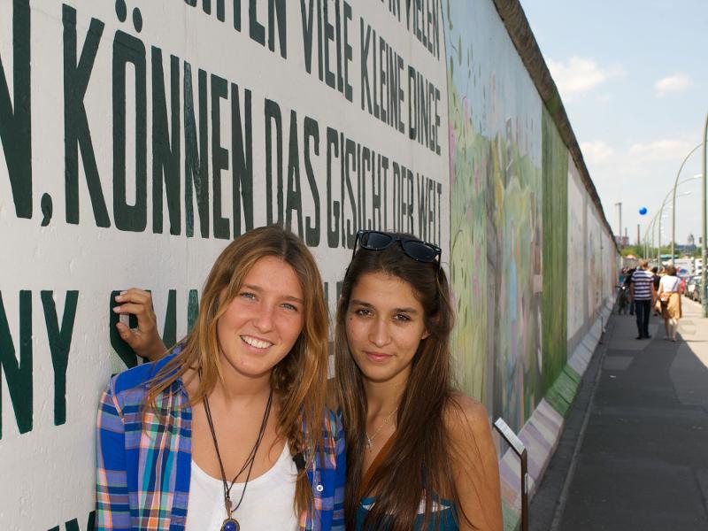 Dos amigas disfrutan de la visita a la east wall gallery en berlin con curso verano alemania
