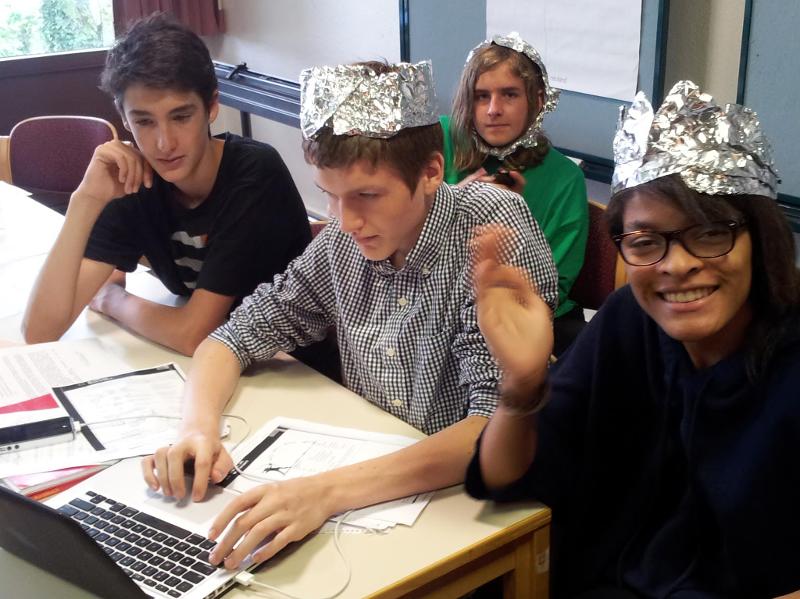 Jóvenes en clase se divierten mientras aprenden con gorros de papel de plata en curso de aleman en alemania