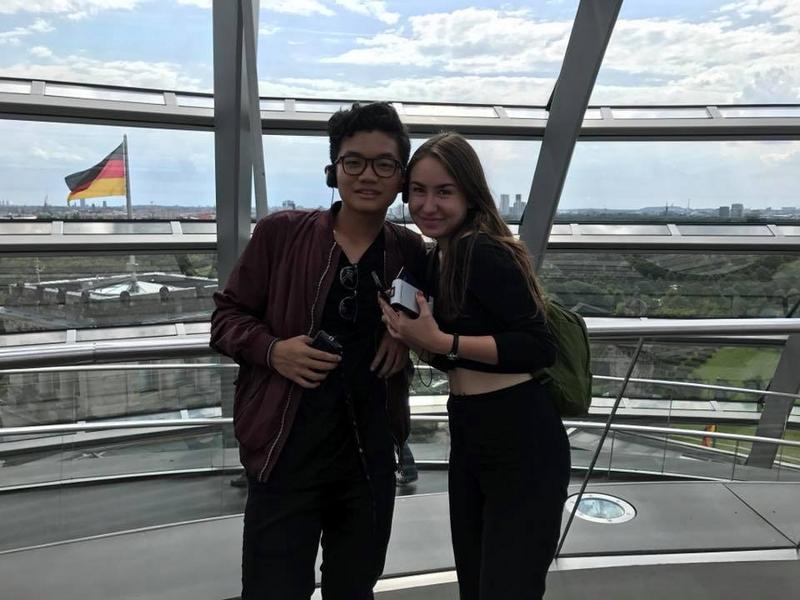 Dos amigos disfrutan de una visita con audioguía en la cúpula de cristal del parlamento aleman con vistas a Berlin en curso de idiomas en alemania