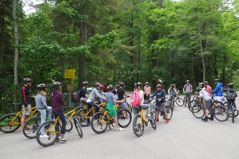 Niños y niñas montados en bicicleta preparados para una excursión por el bosque en curso de aleman en alemania