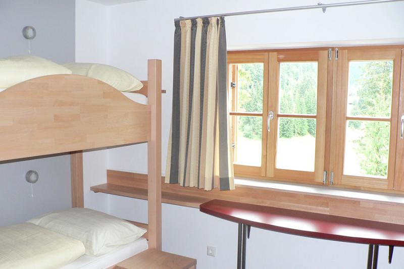 Habitación compartida con una litera con dos camas y una mesa bajo una ventana que da al parque en curso de idiomas en alemania