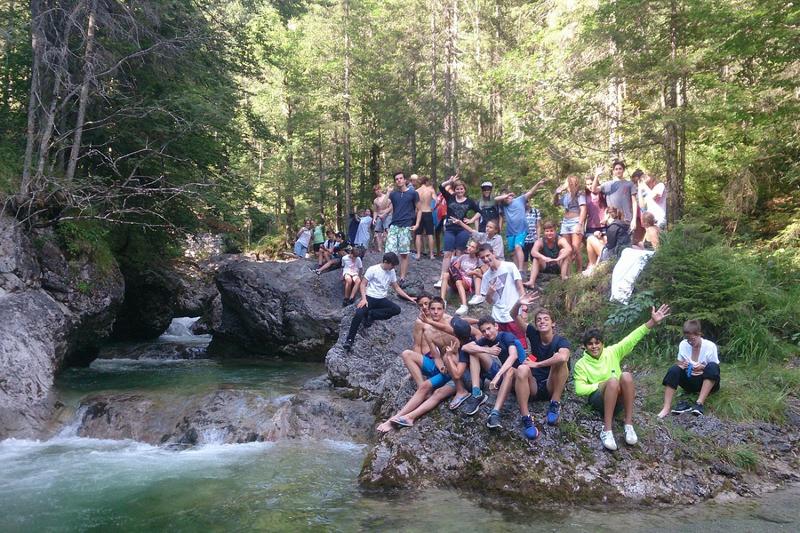 Grupo de campistas posan juntos al lado de una riada de agua entre las rocas y la naturaleza en curso aleman alemania verano