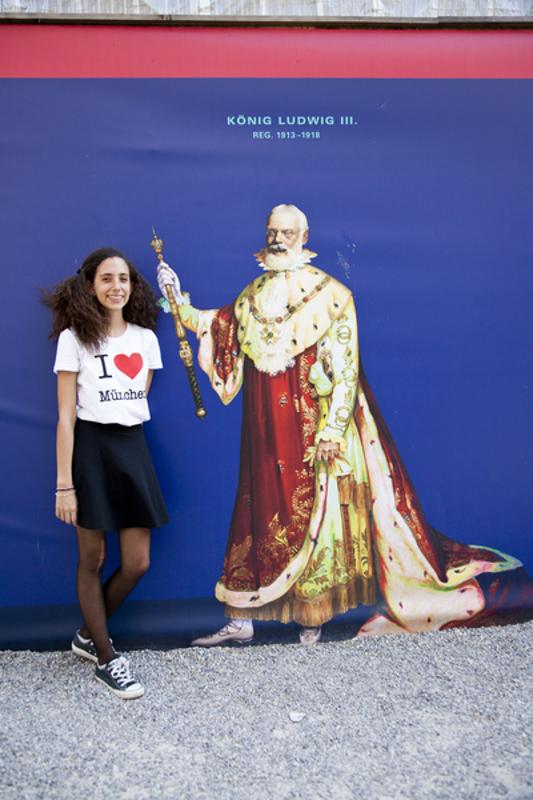 Chica posa con un mural de motivo monárquico en curso de aleman en alemania