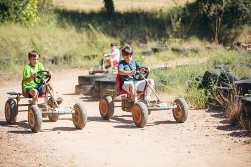 un grupo de niños jugando con kars en campamentos para aprender ingles