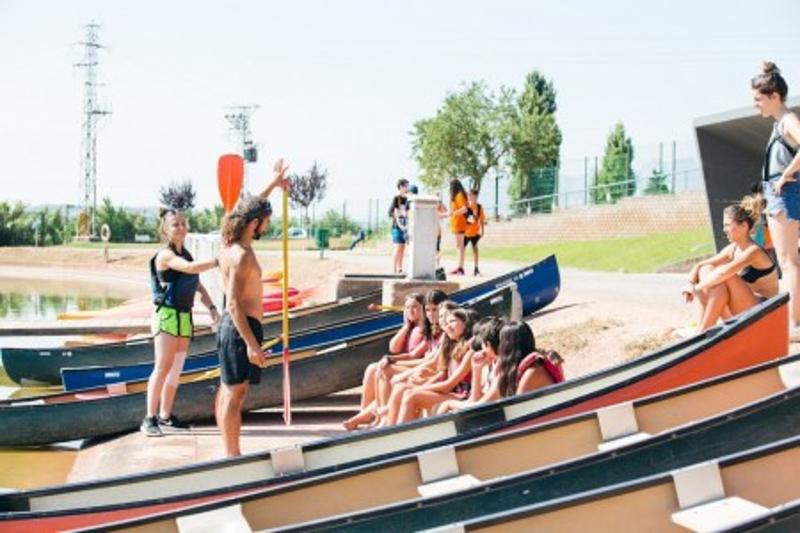 una foto de un monitor en un campamento multiaventura explicando como usar las canoas