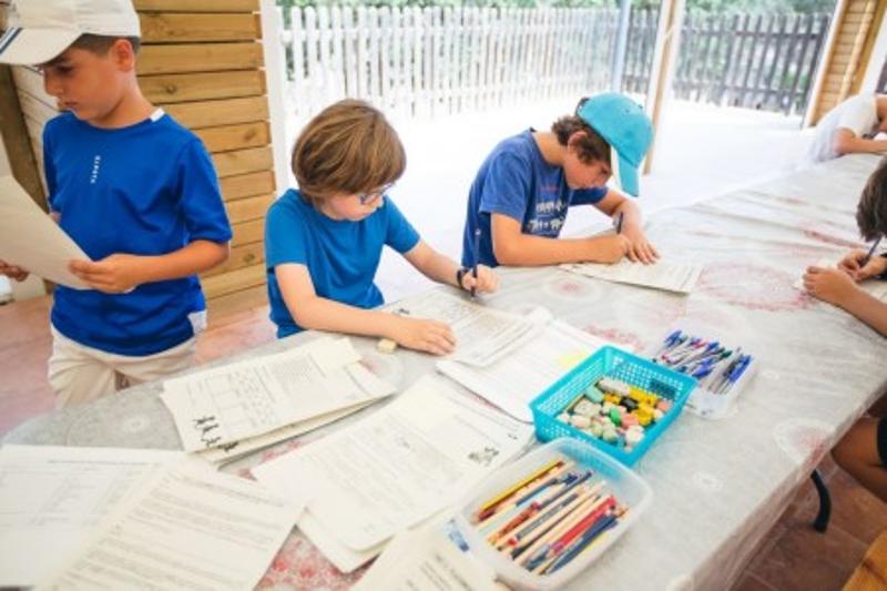 tres niños practicando manualidades en un campamento multiaventura