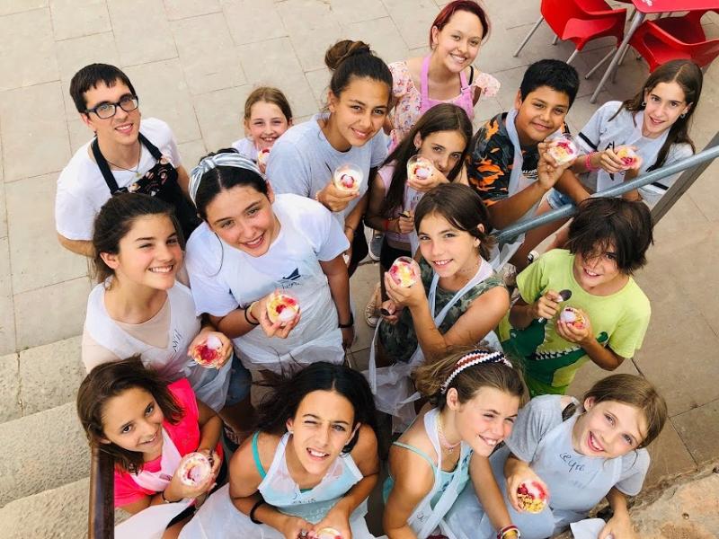 Niños haciendo pasteles en el campamento de verano para aprender ingles
