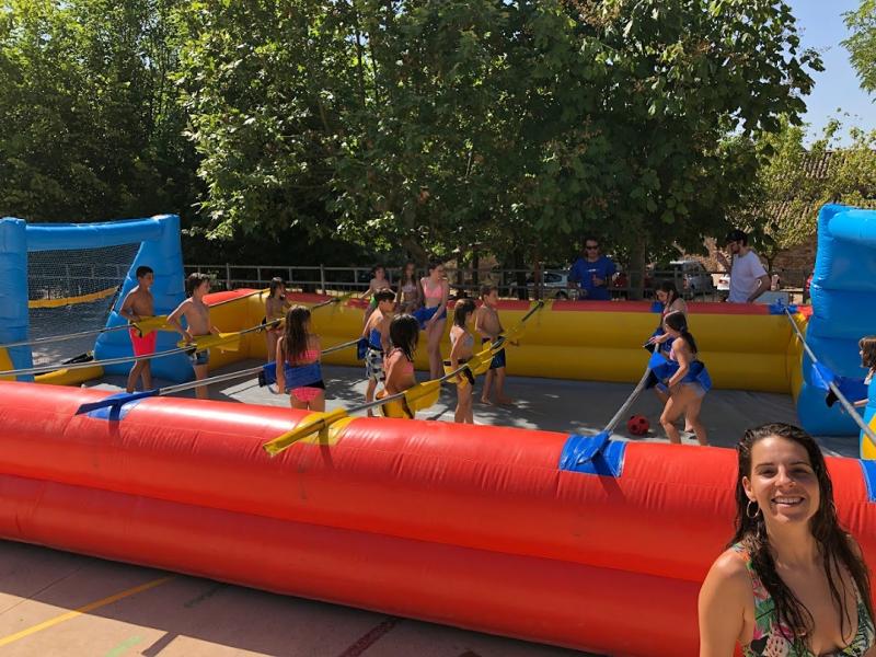 un grupo de niños jugando en un castillo hinchable en un  campamento de verano en barcelona 