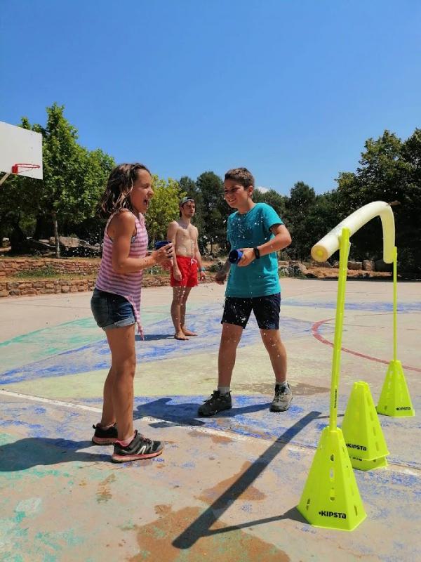 niños jugando con agua en un campamento de verano en barcelona 