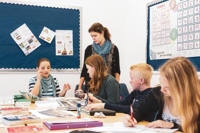 Niños recibiendo lecciones de su profesora durante un curso de ingles